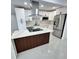 Renovated kitchen showcasing a central island with marble counters and stainless steel appliances at 1778 New Hampshire Ne Ave, St Petersburg, FL 33703