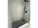 This tiled shower features mosaic tile and a modern, black shower head at 1778 New Hampshire Ne Ave, St Petersburg, FL 33703