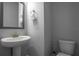 This simple bathroom features a modern pedestal sink, vanity mirror, and toilet at 2110 W Azeele St, Tampa, FL 33606