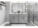 Modern bathroom featuring double vanity, sleek countertops, and glass shower with gray tiling at 2110 W Azeele St, Tampa, FL 33606