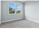 Bright bedroom with natural light, neutral carpeting, and two windows overlooking green trees at 2110 W Azeele St, Tampa, FL 33606
