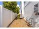 Narrow side yard with white fence, exterior AC and water heater utility box at 2110 W Azeele St, Tampa, FL 33606
