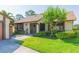 Quaint single-story house with lush greenery, and a cozy screened front entry at 2211 Bay Berry Ln, Clearwater, FL 33763