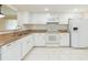 Spacious kitchen showcasing granite countertops, white cabinets, and matching appliances at 2211 Bay Berry Ln, Clearwater, FL 33763