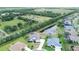 Aerial view of a home with a pool and pond, set in a lush, green landscape at 2214 132Nd E Pl, Parrish, FL 34219
