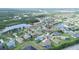 Aerial view of a single-Gathering home in a serene community surrounded by lush greenery and tranquil ponds at 2214 132Nd E Pl, Parrish, FL 34219