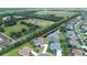 Aerial shot of a home with a pool, pond view, and green surroundings in a residential area at 2214 132Nd E Pl, Parrish, FL 34219