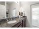 Bathroom featuring a granite countertop, modern fixtures, and a decorative mirror at 2214 132Nd E Pl, Parrish, FL 34219