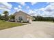 View of home's exterior showing a long driveway leading to a three-car garage at 2214 132Nd E Pl, Parrish, FL 34219
