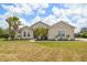 Charming home featuring lush landscaping, a well-maintained lawn, and mature palm trees at 2214 132Nd E Pl, Parrish, FL 34219