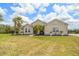 Charming single-story home featuring a landscaped front yard with palm trees and attractive architectural details at 2214 132Nd E Pl, Parrish, FL 34219