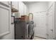 Functional laundry room with gray washer and dryer, white cabinets and walls, and tiled floors at 2214 132Nd E Pl, Parrish, FL 34219