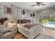 Bright main bedroom with decorative rugs, ceiling fan, and view to the outdoor pool at 2214 132Nd E Pl, Parrish, FL 34219