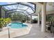 Sparkling blue pool inside screen enclosure with outdoor seating and grill at 2214 132Nd E Pl, Parrish, FL 34219