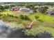 Waterfront property featuring a private dock on a serene lake surrounded by green landscapes at 2333 Camp Indianhead Rd, Land O Lakes, FL 34639