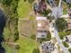 Aerial view of a home with a backyard pool, lush landscaping, and proximity to a serene lake at 2333 Camp Indianhead Rd, Land O Lakes, FL 34639