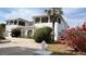 A well-maintained two-story home with white walls, decorative shrubbery and a beautiful bougainvillea at 2333 Camp Indianhead Rd, Land O Lakes, FL 34639