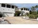 A two-story white home with a well-kept lawn, a three-car garage, and palm trees at 2333 Camp Indianhead Rd, Land O Lakes, FL 34639
