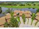 Aerial view of a stunning villa featuring lush landscaping, a pristine lake, and a golf course at 2421 Lake Point Ln, Clearwater, FL 33762