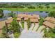 Aerial view of a beautiful villa featuring lush landscaping, a pristine lake, and a golf course at 2421 Lake Point Ln, Clearwater, FL 33762