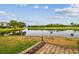 Backyard view of a pond and golf course, framed by brick edging and lush green grass at 2421 Lake Point Ln, Clearwater, FL 33762