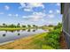 A picturesque pond view with golf course in background; red hibiscus visible in yard at 2421 Lake Point Ln, Clearwater, FL 33762