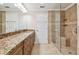 Bathroom with dual sinks, granite countertops, tile floors, glass enclosed shower and updated fixtures at 2421 Lake Point Ln, Clearwater, FL 33762