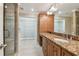 Bathroom featuring granite countertops, cabinets, large mirrors, glass enclosed shower and walk in closet at 2421 Lake Point Ln, Clearwater, FL 33762