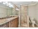 Bathroom featuring granite countertop vanity, glass-enclosed shower with seat, and neutral tile floors at 2421 Lake Point Ln, Clearwater, FL 33762