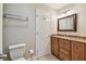 Bathroom featuring a toilet, towel rack, mirror, lighting, and vanity with granite counters and wood cabinets at 2421 Lake Point Ln, Clearwater, FL 33762