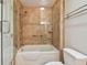 Bathroom boasts a tiled shower, glass doors, grab bar, tiled walls, and a toilet in the foreground at 2421 Lake Point Ln, Clearwater, FL 33762