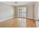 Bedroom with natural light and hardwood floors leading to an exterior door with shutter coverings at 2421 Lake Point Ln, Clearwater, FL 33762