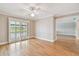 Bright bedroom featuring hardwood floors, sliding doors to the outside, and a ceiling fan at 2421 Lake Point Ln, Clearwater, FL 33762
