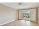 Bedroom features neutral walls, light wood flooring, ceiling fan, and sliding glass doors to outdoor patio area at 2421 Lake Point Ln, Clearwater, FL 33762