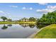 Exterior view of a clubhouse on a golf course with a large pond in the foreground at 2421 Lake Point Ln, Clearwater, FL 33762