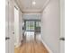 Hallway with wood flooring, white trim, and access to multiple rooms including a living area with fireplace at 2421 Lake Point Ln, Clearwater, FL 33762