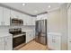 Modern kitchen features stainless steel appliances, white cabinets, and subway tile backsplash at 2421 Lake Point Ln, Clearwater, FL 33762