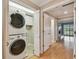 Laundry closet with stacked washer and dryer along with a storage cabinet at 2421 Lake Point Ln, Clearwater, FL 33762
