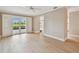 Open-concept living area boasts light wood flooring, sliding glass doors to an outdoor patio, and neutral walls at 2421 Lake Point Ln, Clearwater, FL 33762