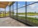 The screened patio features large windows with a view of the lake and golf course beyond at 2421 Lake Point Ln, Clearwater, FL 33762