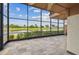 The tiled patio is enclosed with black framed screen windows, offering a view of a pond and golf course at 2421 Lake Point Ln, Clearwater, FL 33762