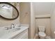 Neutral powder room featuring vanity with quartz countertop and round mirror at 2421 Lake Point Ln, Clearwater, FL 33762