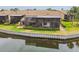 Back of villa overlooking the water featuring a screened in porch and manicured landscaping at 2421 Lake Point Ln, Clearwater, FL 33762