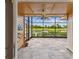 Sunroom featuring tiled floors, wood paneling, a ceiling fan, and golf course and lake views at 2421 Lake Point Ln, Clearwater, FL 33762