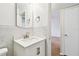 Well-lit bathroom with a sink vanity and marble patterned walls and a view into the living area at 2469 Franciscan Dr # 59, Clearwater, FL 33763