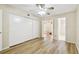 Comfortable bedroom with wood-look floors, bright ceiling fan, and view to the enclosed patio at 2469 Franciscan Dr # 59, Clearwater, FL 33763