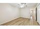 Bright bedroom with a ceiling fan, wood-look floors, and a view into the bathroom at 2469 Franciscan Dr # 59, Clearwater, FL 33763