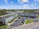 Aerial view showcasing the exterior of a light-colored condo building with parking and green spaces at 2469 Franciscan Dr # 59, Clearwater, FL 33763