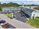Aerial view of a light-colored condo complex featuring parking lots, and manicured green spaces at 2469 Franciscan Dr # 59, Clearwater, FL 33763