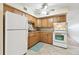 Classic kitchen featuring wood cabinets, white appliances and tile flooring at 2469 Franciscan Dr # 59, Clearwater, FL 33763